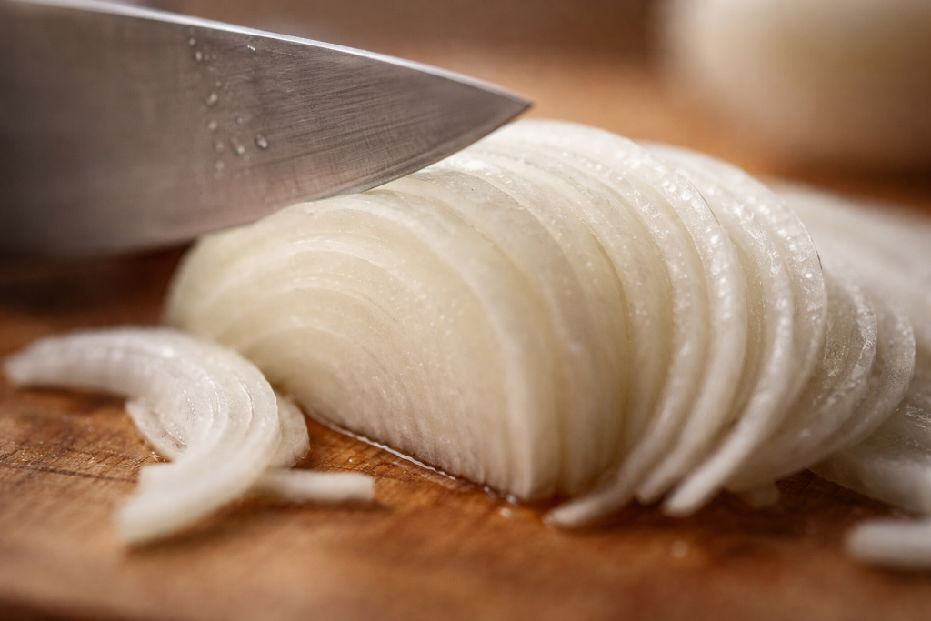 [light] Detaljeshot til ‘feature’: ekstremt tæt billede af knivteknik eller tekstur (fx snit i løg, saltflager, stegeskorpe)—viser håndværk og kvalitet.